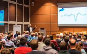 A large auditorium filled with professionals at a business convention